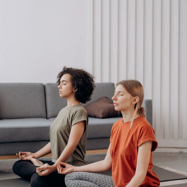 Person meditating in a bright room, focusing on their breath.
